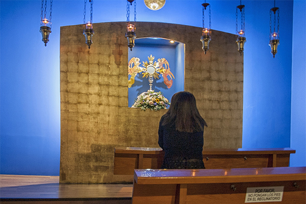 Una fiel ora ante el altar de la capilla de la Adoración Eucarística Perpetua de Elche. Foto: J. FILIU